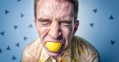 Mann beißt in Zitrone